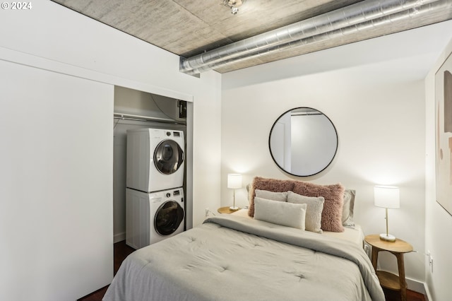 bedroom featuring a closet, stacked washer and clothes dryer, and dark hardwood / wood-style flooring