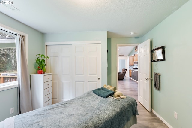 bedroom featuring a textured ceiling, hardwood / wood-style flooring, and a closet