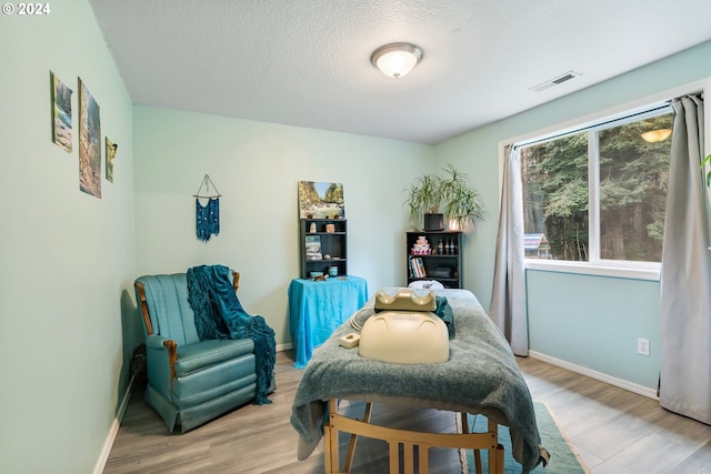 sitting room with a textured ceiling and light hardwood / wood-style floors