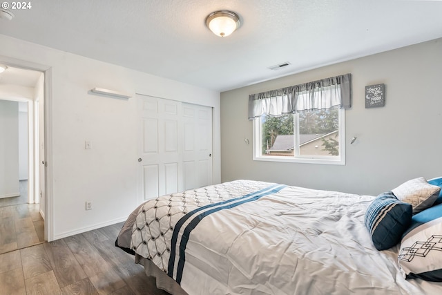 bedroom with hardwood / wood-style floors and a closet