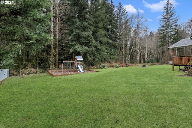 view of yard featuring a playground and a wooden deck