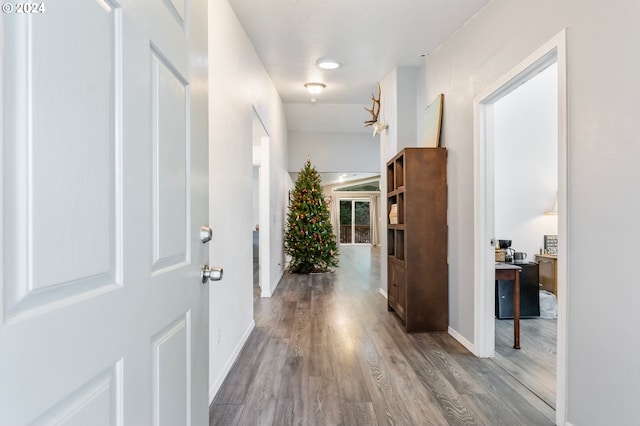 corridor with hardwood / wood-style floors and a textured ceiling