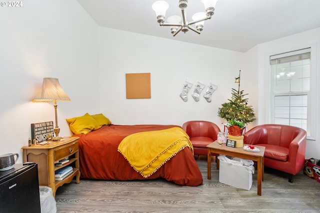 bedroom featuring wood-type flooring and a notable chandelier