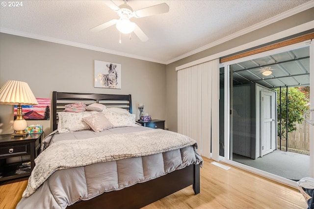 bedroom with a textured ceiling, light hardwood / wood-style flooring, access to exterior, ornamental molding, and ceiling fan