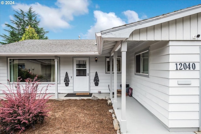 view of exterior entry with a porch and board and batten siding