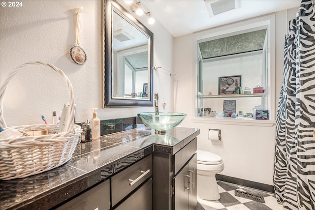 bathroom featuring tile patterned flooring, vanity, and toilet