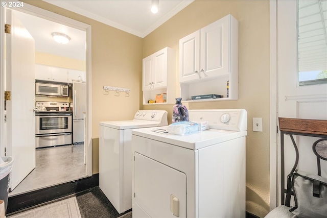 laundry room featuring crown molding, cabinets, and washing machine and clothes dryer