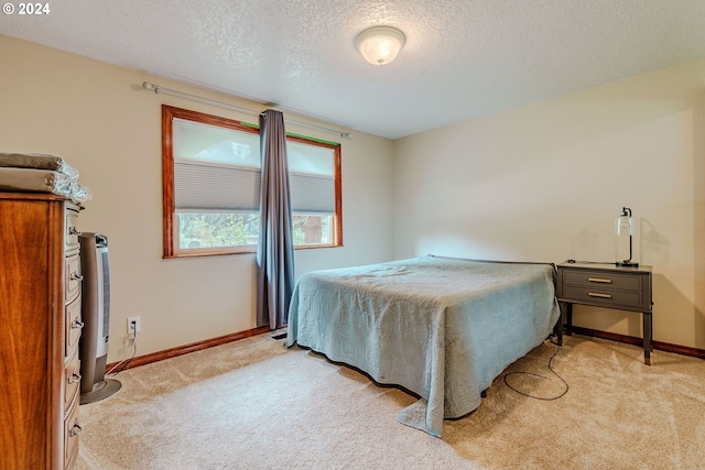 bedroom featuring a textured ceiling and light carpet