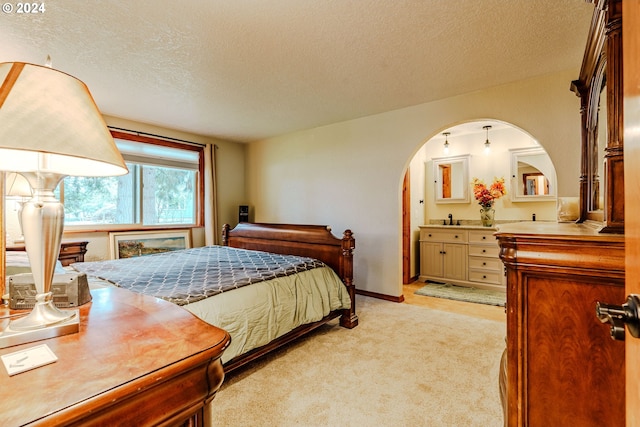 bedroom with light colored carpet, a textured ceiling, and sink