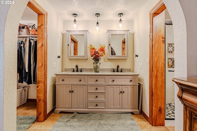 bathroom featuring hardwood / wood-style flooring, vanity, and a textured ceiling