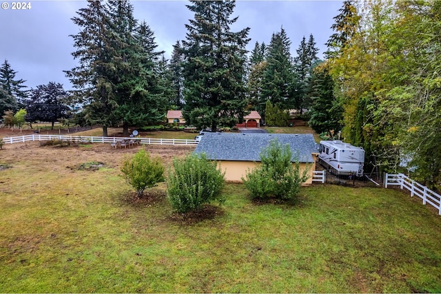 view of swimming pool with a rural view and a lawn