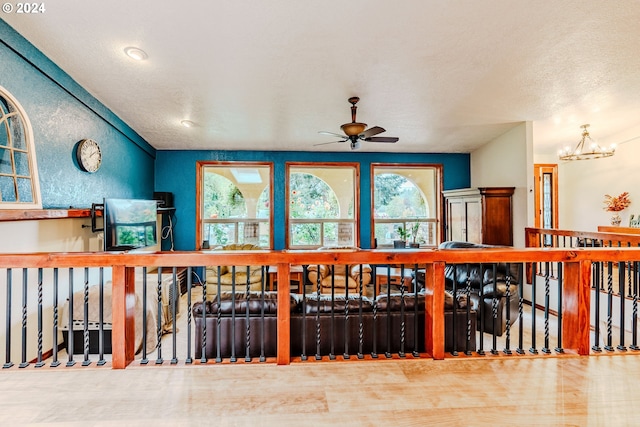 interior space with ceiling fan with notable chandelier and a textured ceiling