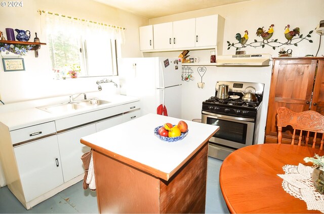 kitchen with stainless steel gas stove, white fridge, range hood, sink, and white cabinets