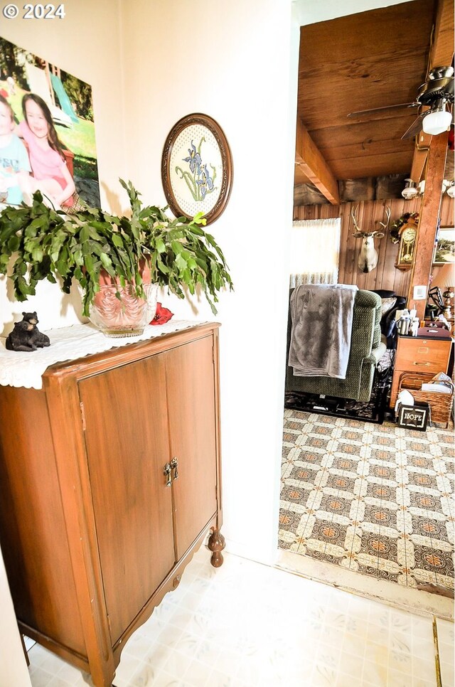 interior space with wood walls and ceiling fan