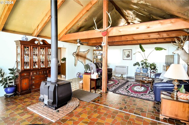 living room with lofted ceiling with beams, a wood stove, and heating unit