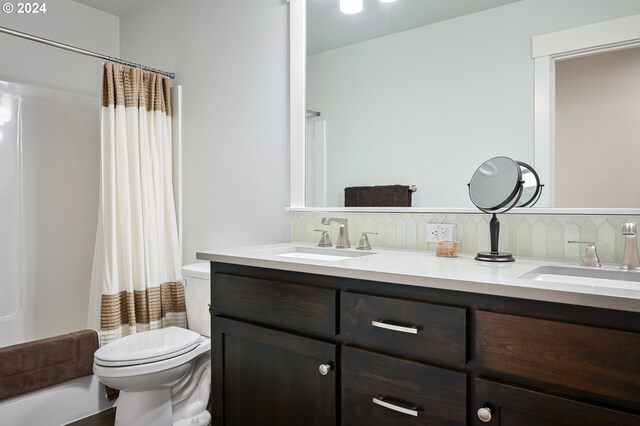 full bathroom with toilet, shower / tub combo with curtain, decorative backsplash, and vanity