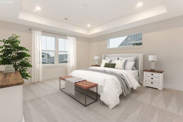 carpeted bedroom with a raised ceiling