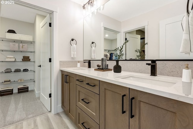 bathroom with backsplash, vanity, and hardwood / wood-style flooring