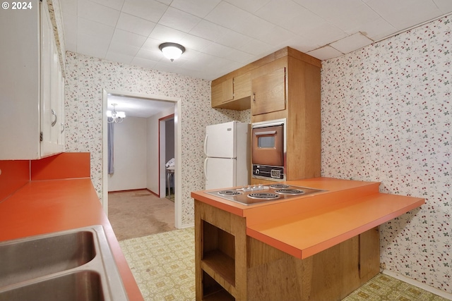 kitchen with light colored carpet, white refrigerator, an inviting chandelier, kitchen peninsula, and stainless steel electric stovetop