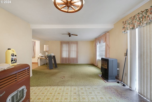 interior space with a wood stove and ceiling fan