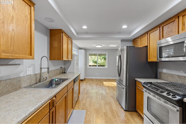 31205 NE 152nd Ave, Battle Ground, WA 98604 - kitchen with stainless steel appliances, a sink, light wood finished floors, brown cabinets, and light countertops