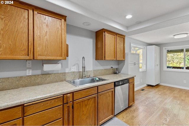31205 NE 152nd Ave, Battle Ground, WA 98604 - kitchen featuring stainless steel dishwasher, a sink, light wood-style flooring, light countertops, and brown cabinetry
