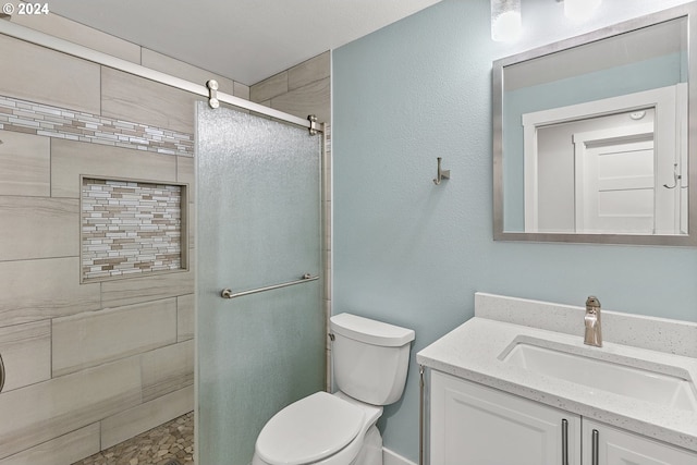 bathroom featuring vanity, toilet, and a shower with door