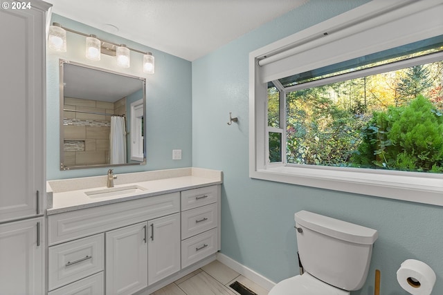 bathroom with toilet, vanity, and a shower with shower curtain