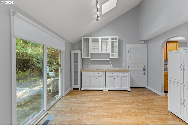 31205 NE 152nd Ave, Battle Ground, WA 98604 - kitchen featuring arched walkways, high vaulted ceiling, white cabinets, glass insert cabinets, and light wood-style flooring