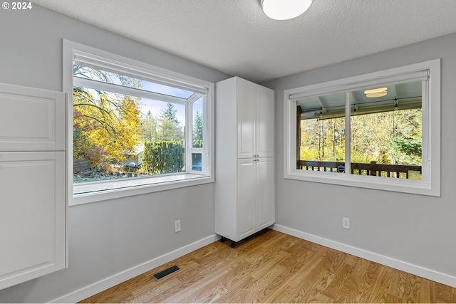 unfurnished bedroom featuring a textured ceiling and light wood-type flooring