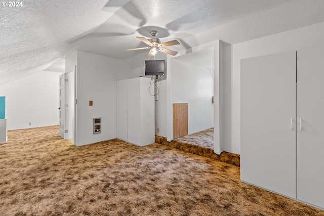 additional living space with ceiling fan, a textured ceiling, carpet flooring, and vaulted ceiling