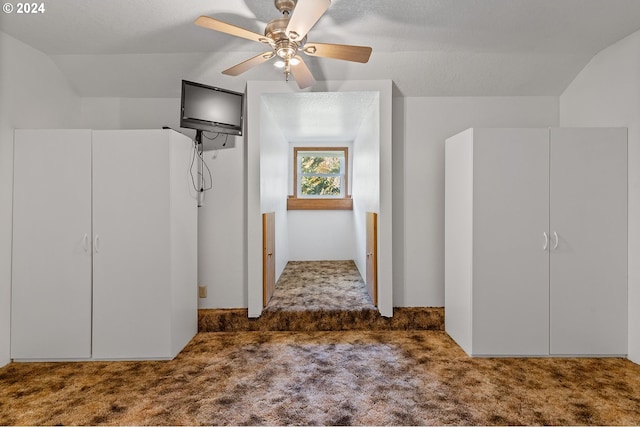 interior space with lofted ceiling, a textured ceiling, and ceiling fan