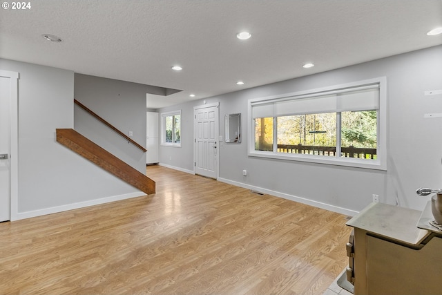 foyer entrance featuring a textured ceiling and light hardwood / wood-style flooring