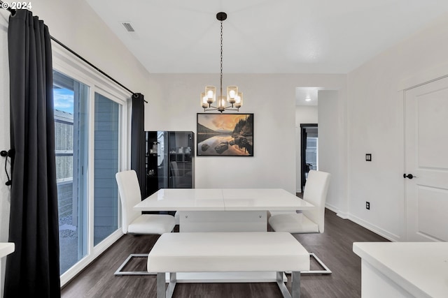 dining room with dark hardwood / wood-style flooring and a notable chandelier