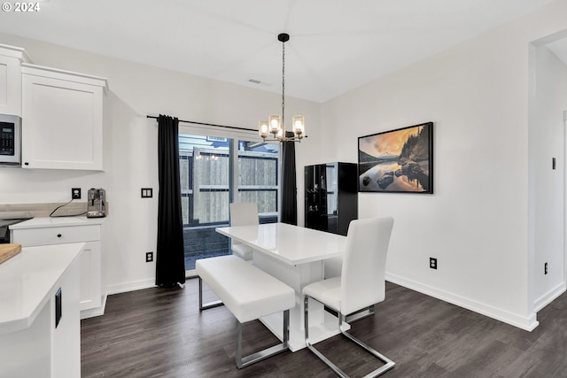 dining area featuring an inviting chandelier and dark wood-type flooring