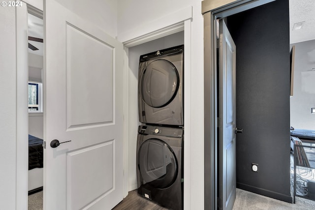 laundry area with stacked washer and dryer and ceiling fan