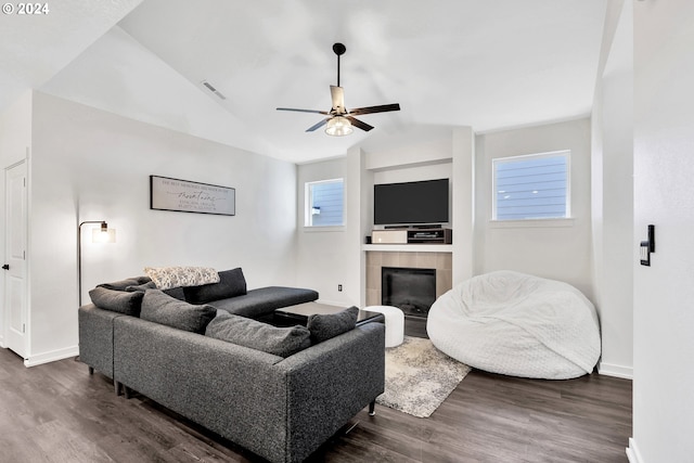 living room featuring ceiling fan, lofted ceiling, a fireplace, and dark wood-type flooring