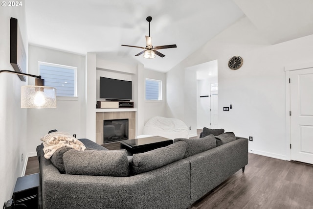 living room featuring plenty of natural light, a tiled fireplace, ceiling fan, and dark hardwood / wood-style flooring