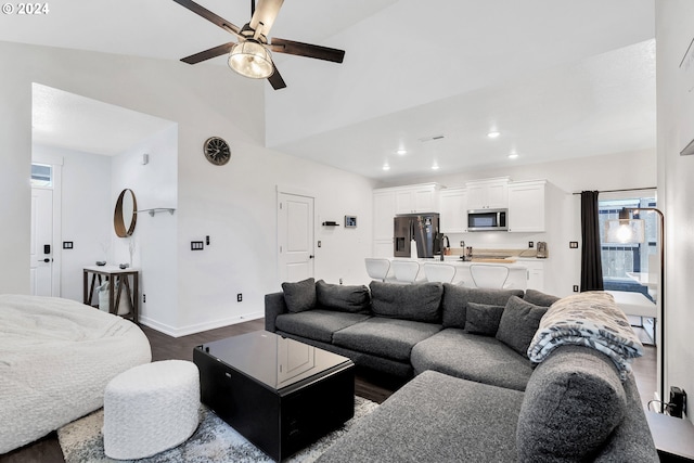 living room with vaulted ceiling, ceiling fan, and dark hardwood / wood-style flooring