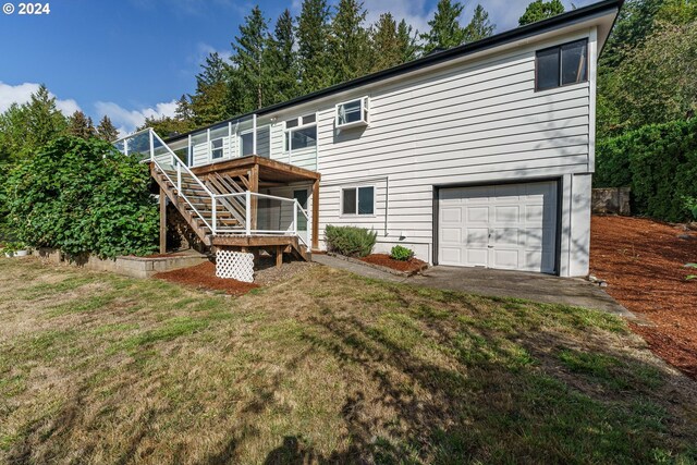 back of property with a garage, a wooden deck, and a yard