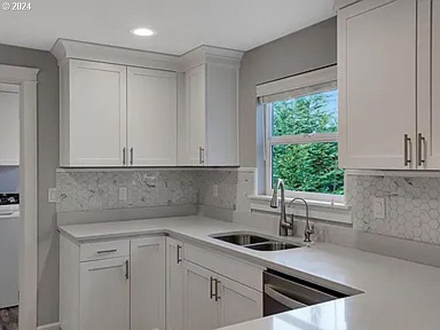 kitchen featuring sink, white cabinets, dishwasher, and tasteful backsplash