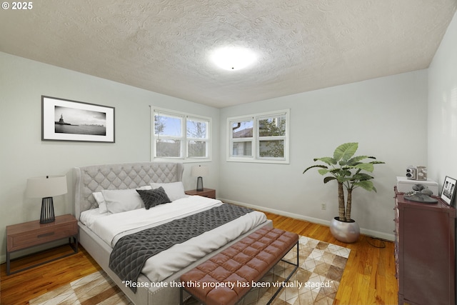 bedroom with hardwood / wood-style flooring and a textured ceiling