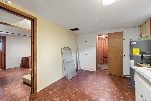 bathroom featuring water heater and a textured ceiling