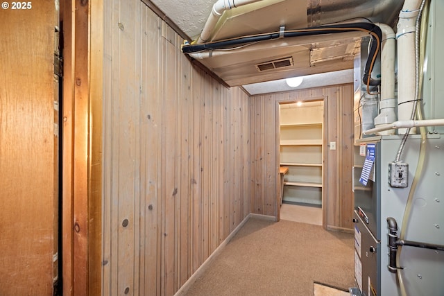 interior space featuring wooden walls and light colored carpet