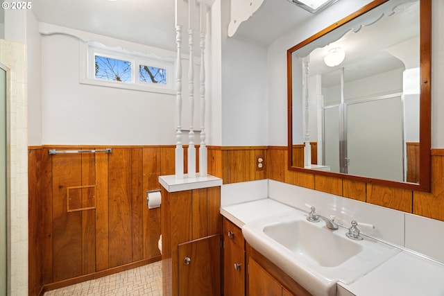 bathroom featuring vanity, wooden walls, and a shower with door