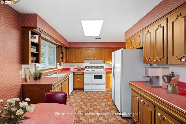 kitchen featuring sink, white appliances, and a skylight