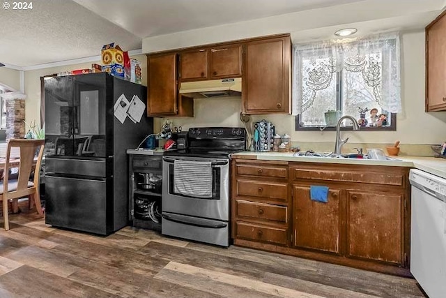 kitchen featuring dishwasher, black refrigerator, electric stove, sink, and dark hardwood / wood-style floors