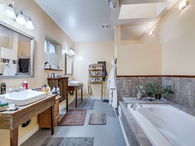 bathroom featuring sink and a relaxing tiled tub