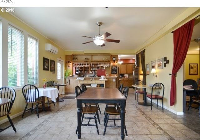 tiled dining space with a wall mounted air conditioner, indoor bar, and ceiling fan