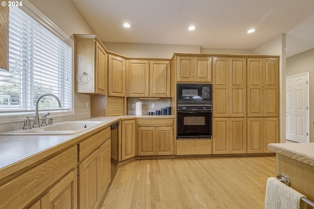 kitchen with sink, black appliances, and light hardwood / wood-style flooring